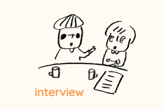 イラスト。２人がテーブルに隣り合って座り話している。下にはinterviewと書かれている。