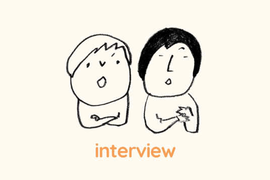 イラスト。２人の人が並んで腕組みをしながら話している。下にinterviewと書かれている。