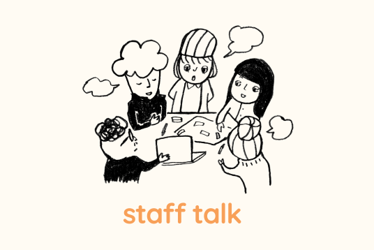 イラスト。4人の人がパソコンや紙が置かれたテーブルを囲んでモヤモヤ話あっている様子。staff talkとイラストの下に書かれている。