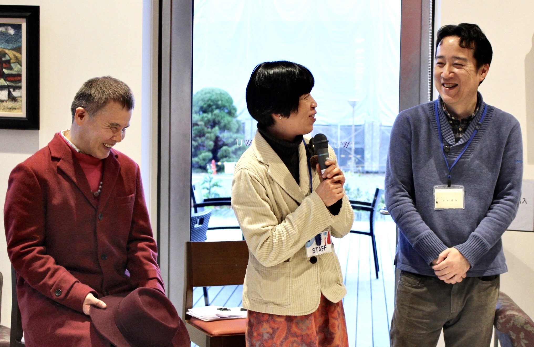 左から濱田さん、松尾さん、石田さんが並んで笑顔で喋っている様子。松尾さんはマイクを持ち、濱田さんは帽子を手にしている。