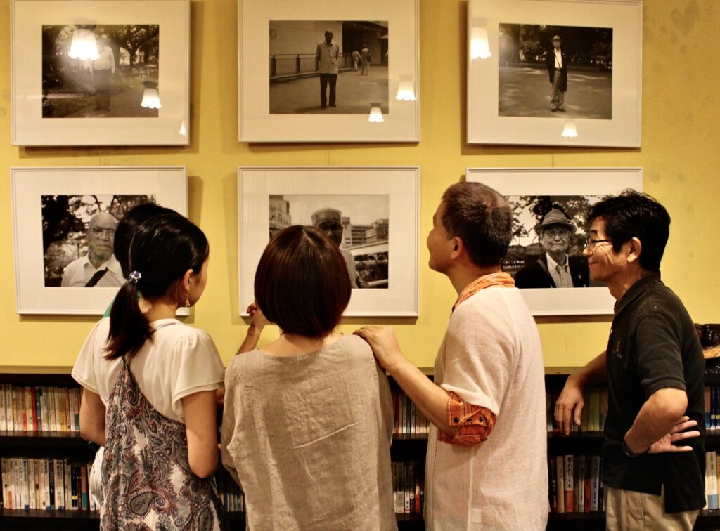 奥の壁にかかった写真を囲んでグループでしゃべっている様子