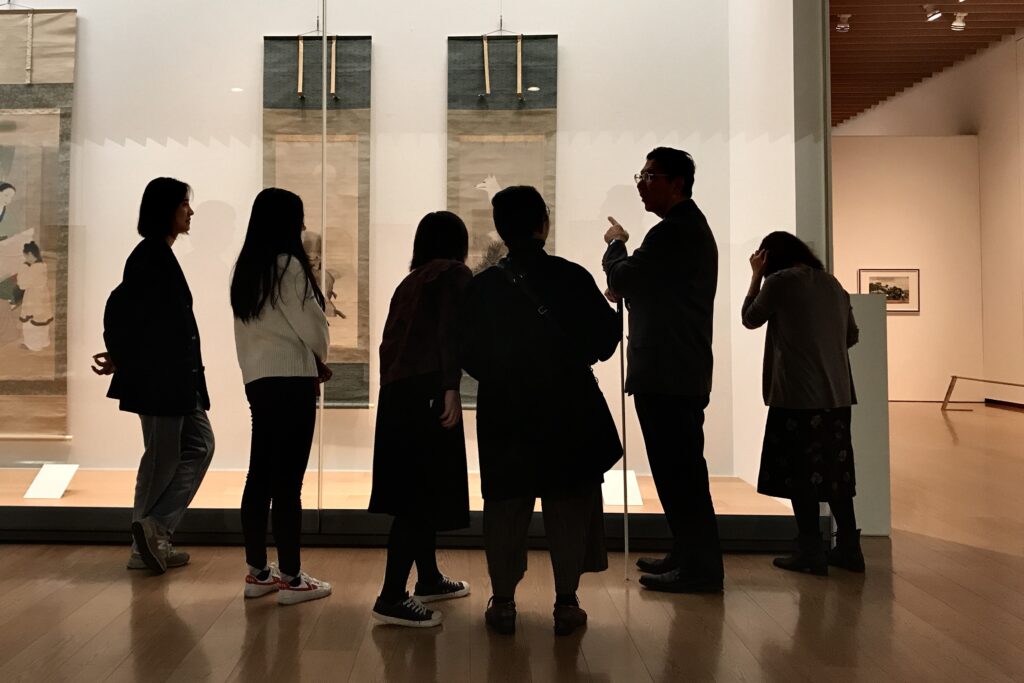 奥に掛けられた掛け軸を囲んでギャラリーコンパをしている様子